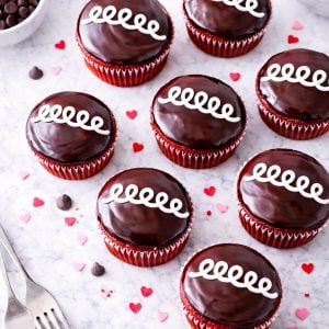 These bakery-style red velvet cupcakes are filled with sweet vanilla cream and finished with a chocolate ganache topping. A fun, nostalgic dessert recipe everyone will love.