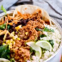 Make the famous Café Rio sweet pork salad at home—tender pork, cilantro-lime rice, beans, tomatillo-ranch, and all the crunchy toppings.